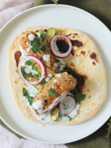 2 Vegan Tofu Kofta with mint yogurt, red onion and baby courgettes served on a flatbread