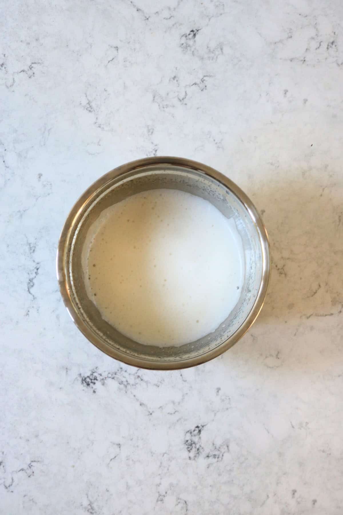 Whisked aquafaba in a metal mixing bowl