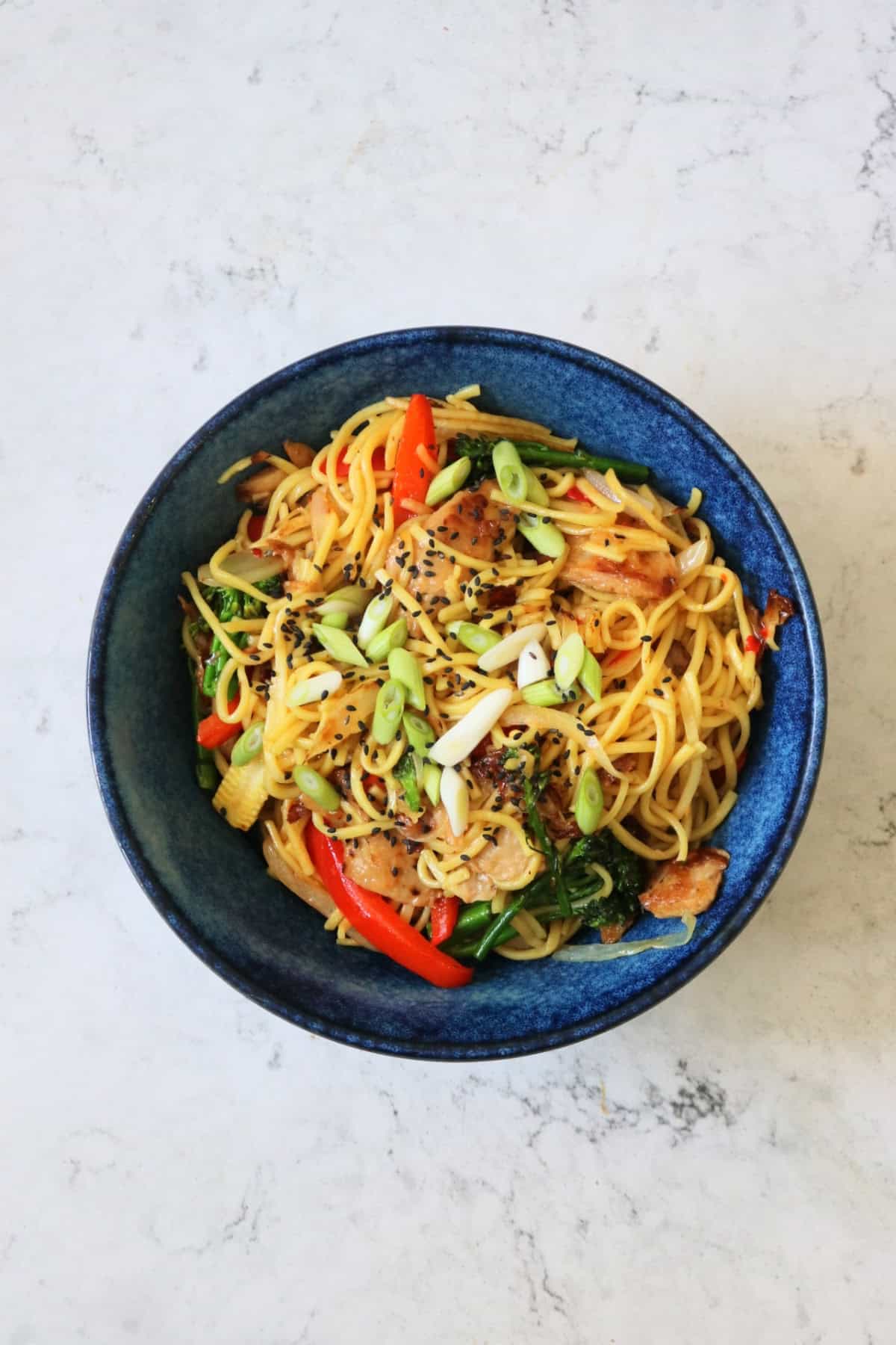 A serving of Vegan Sweet Chilli Chicken Noodles in a dark blue bowl