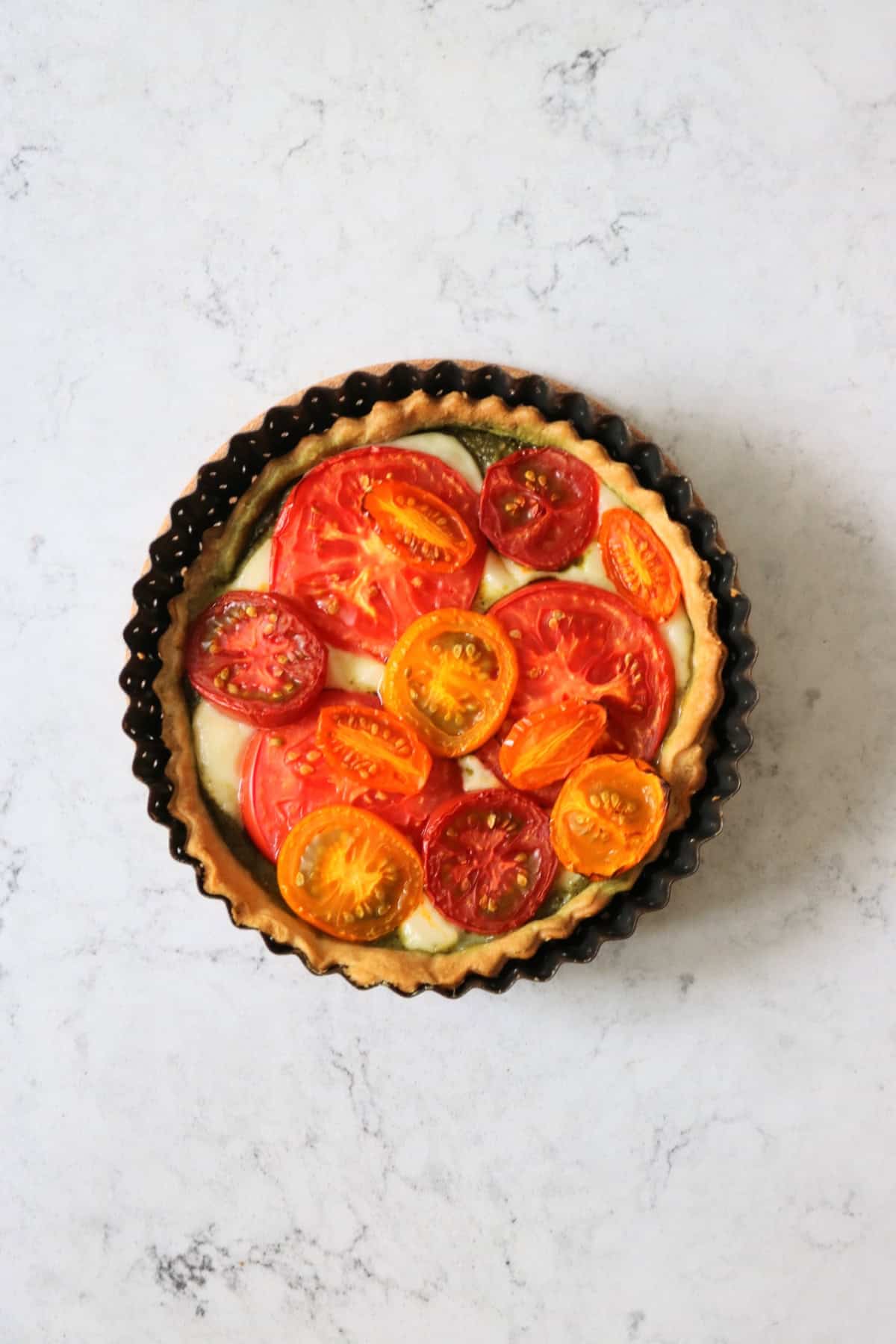 Vegan Tomato Mozzarella and Pesto Picnic Tart, fresh out of the oven and still in the tin