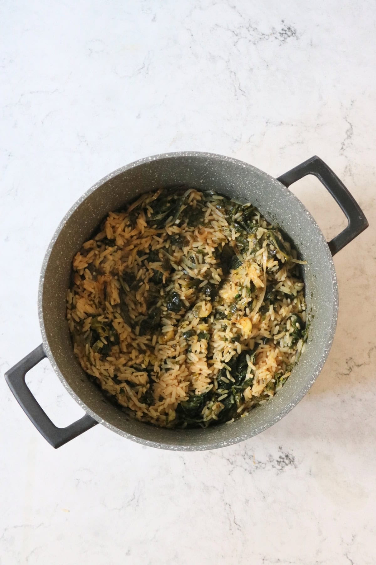 Cooked Greek Spinach Rice with Vegan Feta in a large pan