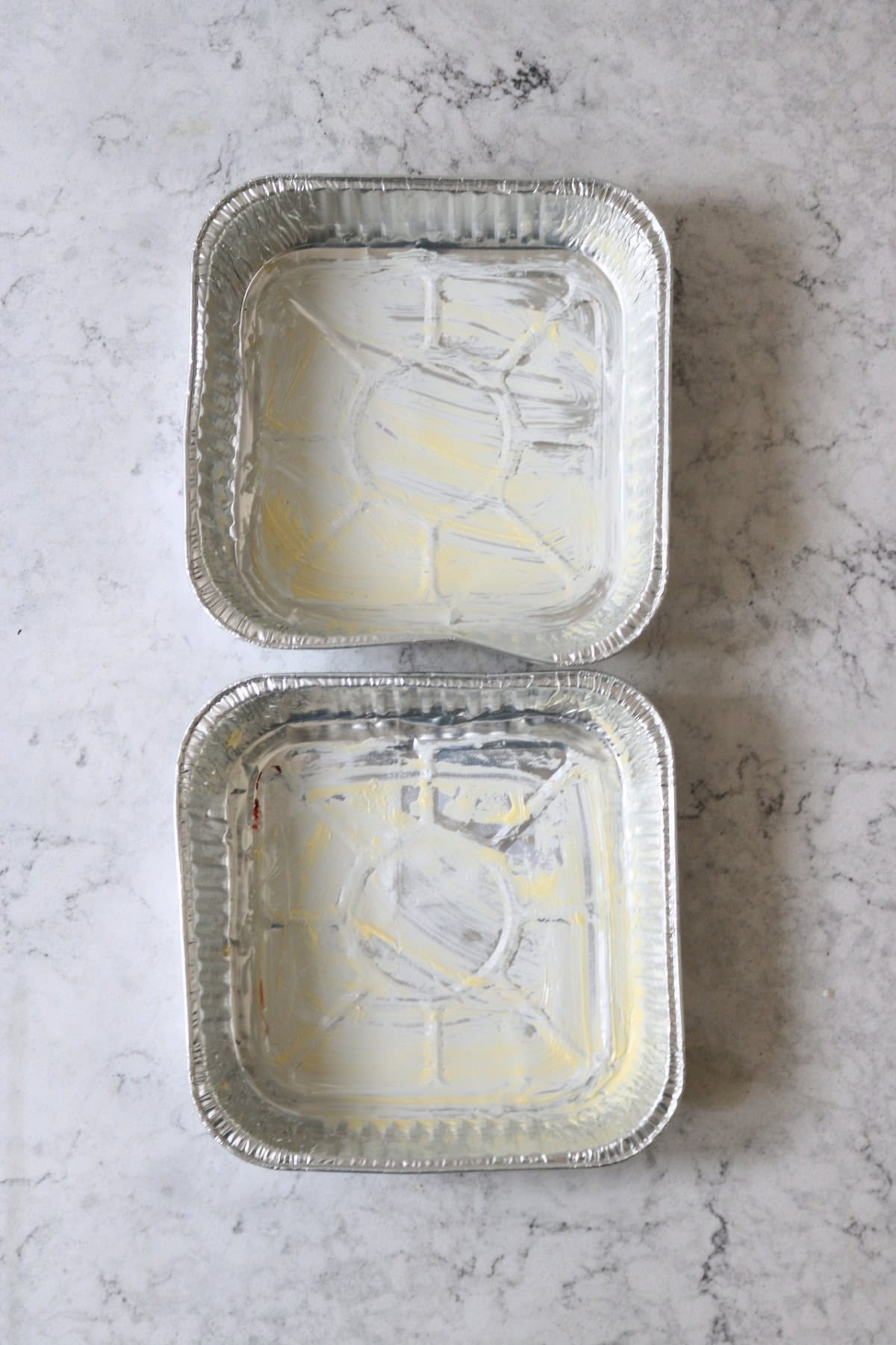 Two greased tin foil trays