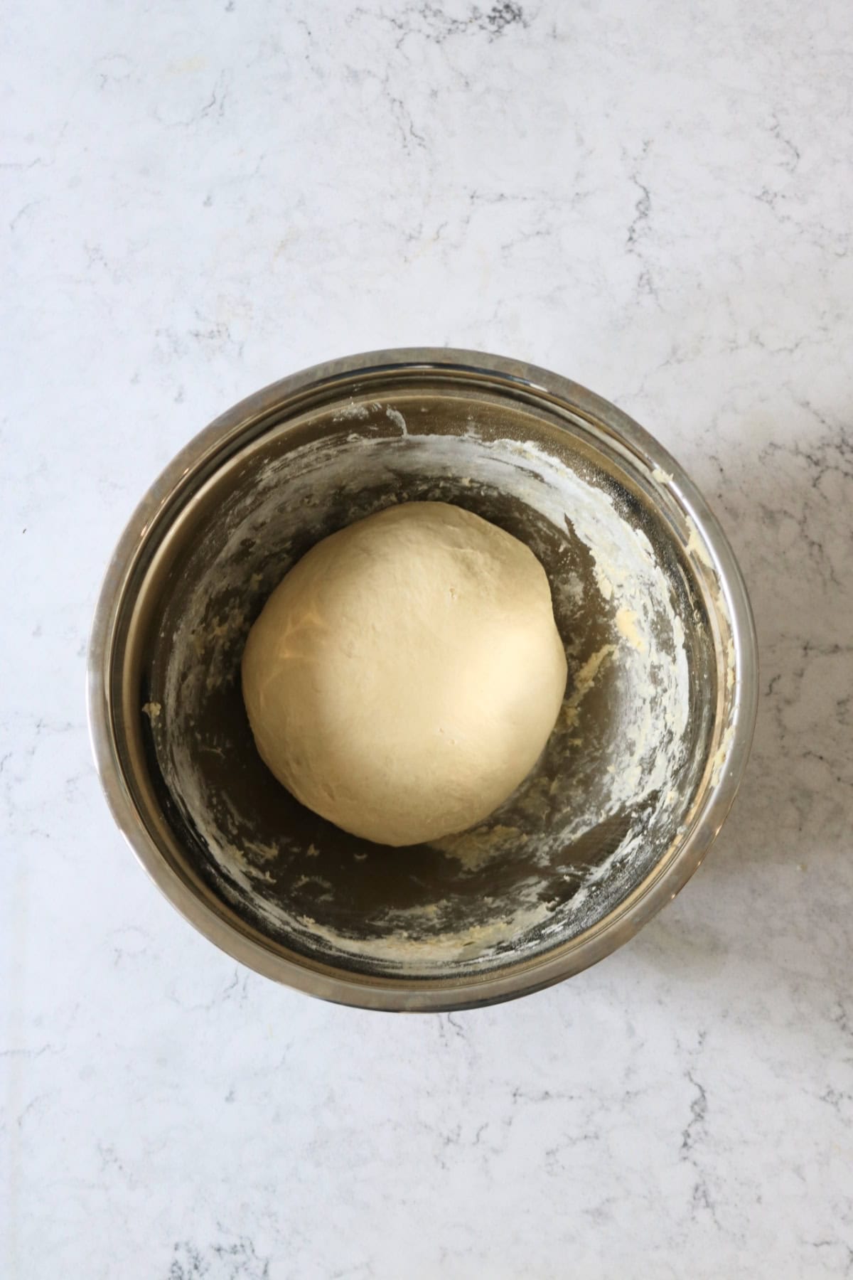 Plain Vegan Halloween Pumpkin Spice Rolls dough in a large metal mixing bowl