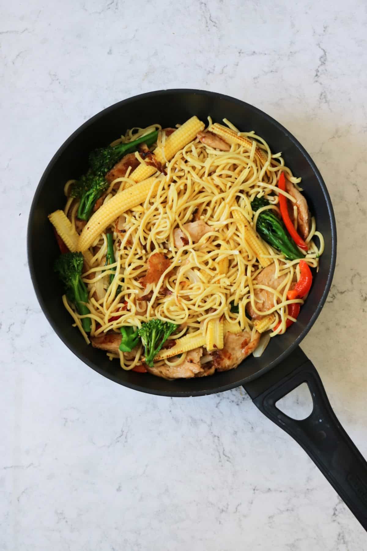 Stir Frying Vegan Sweet Chilli Chicken Noodles in a flat bottomed frying pan