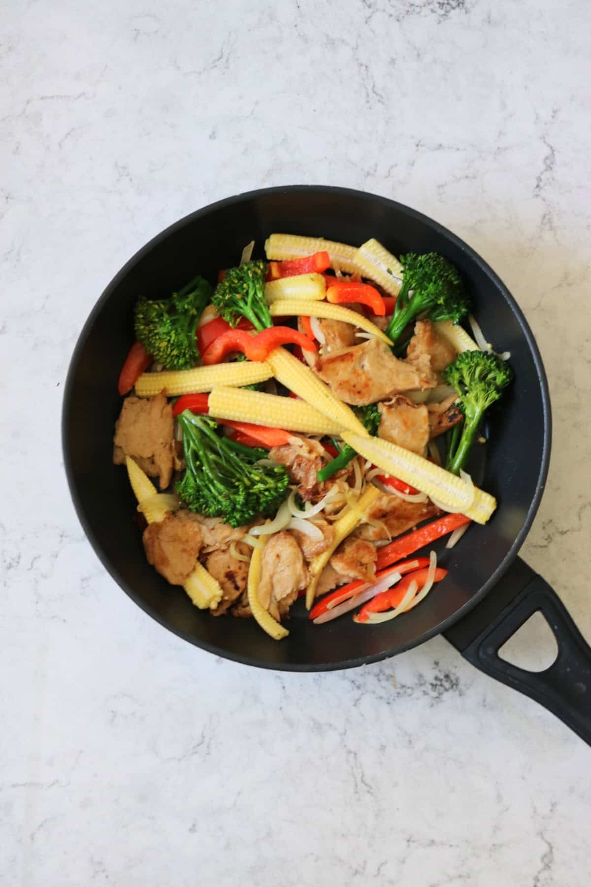 Stir frying vegan chicken and veggies for Vegan Sweet Chilli Chicken Noodles