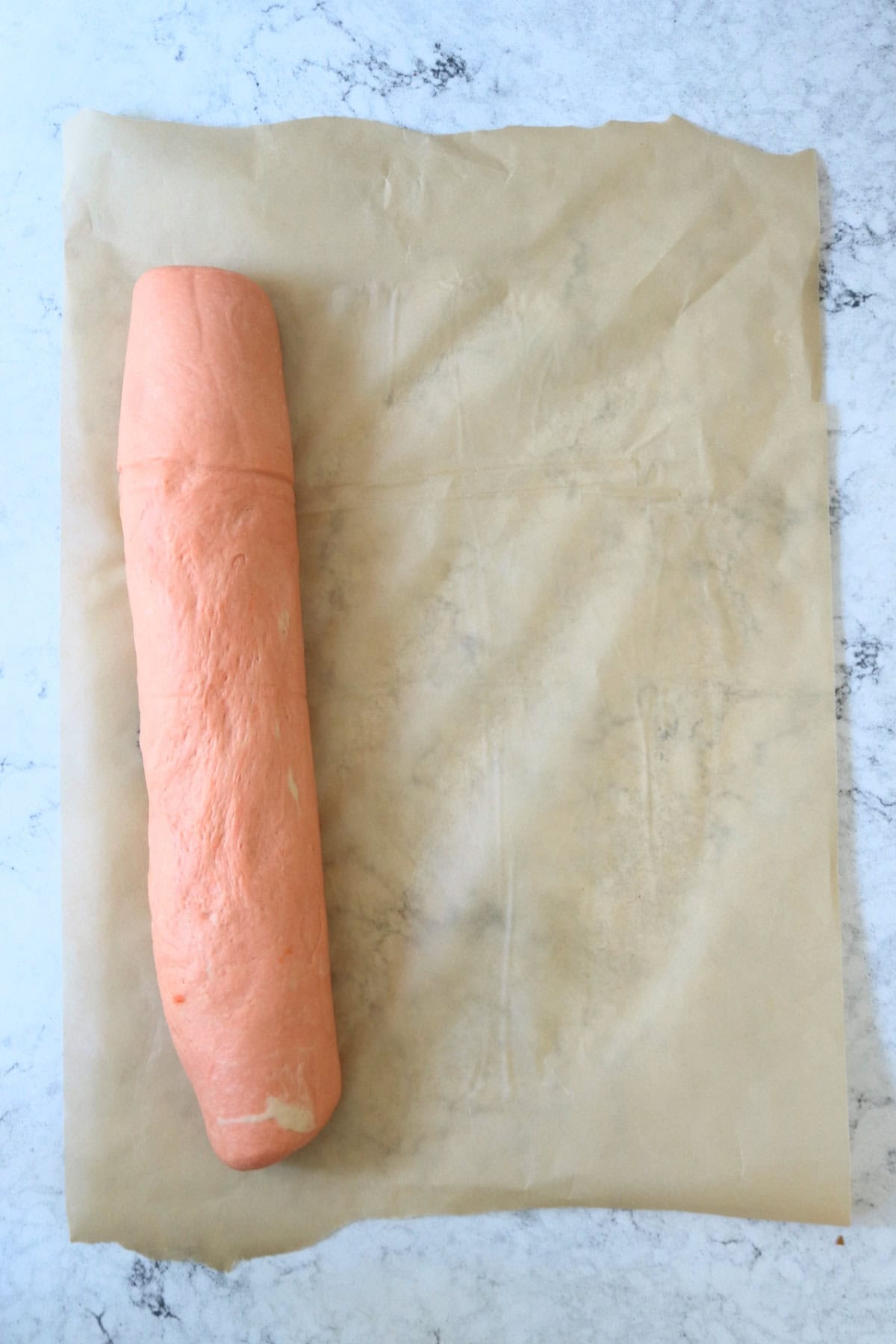 Vegan Halloween Pumpkin Spice Rolls rolled up into a log ready to be cut into individual rolls