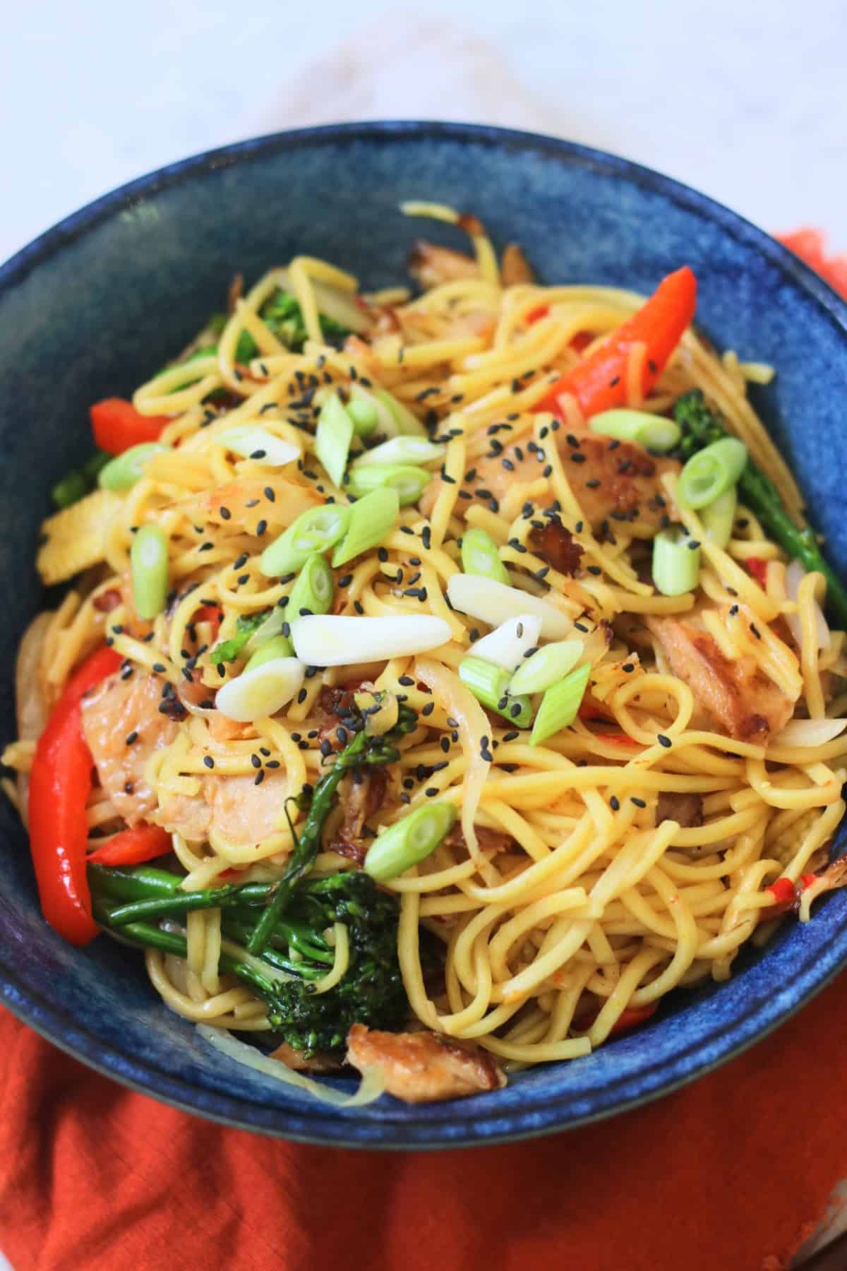 A bowl of Vegan Sweet Chilli Chicken Noodles on a red napkin