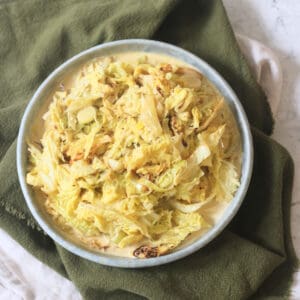 A side dish of Vegan Creamed Cabbage and Leeks served with a dark green napkin