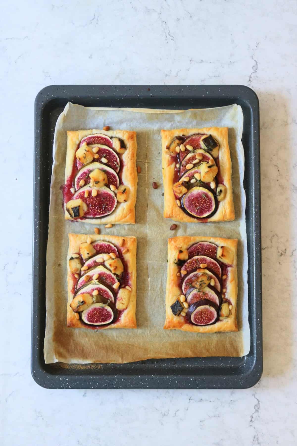 Four baked Vegan Fig and Blue Cheese Tarts on a baking tray