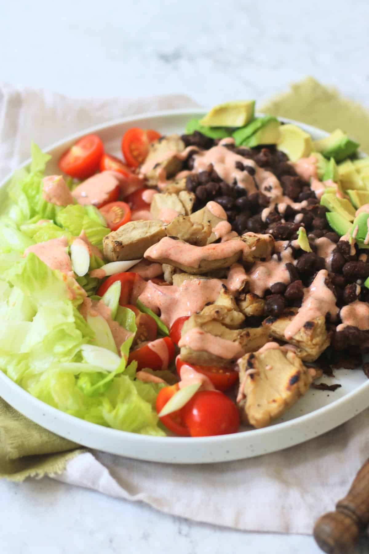 Vegan Chicken and Avocado Salad with Black Beans and a Smoky Paprika Yogurt Dressing drizzled over the top
