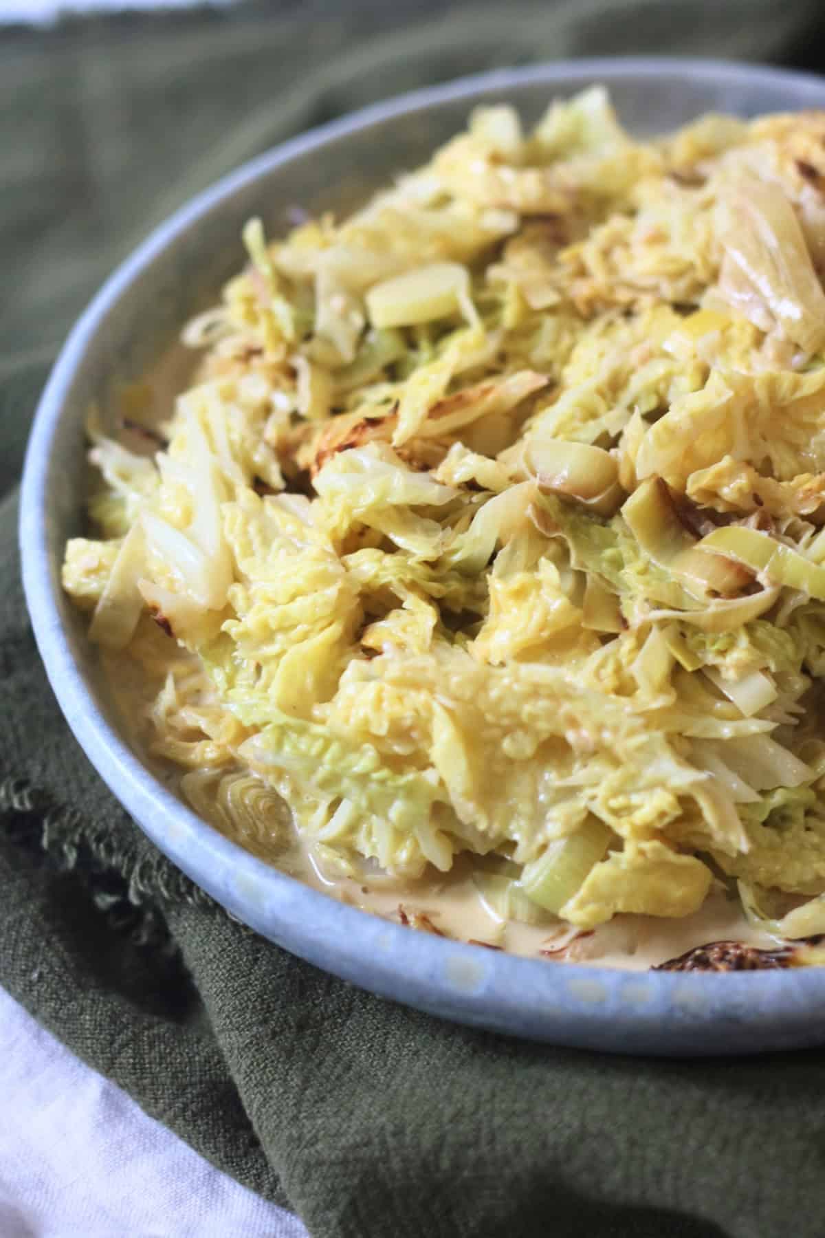 A side dish of Vegan Creamed Cabbage and Leeks served with a dark green napkin